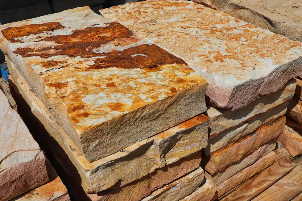 Rust-veined natural stone slabs stacked in the yard at Danilo's Landscape Supply